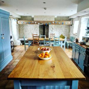 eine Küche mit einem Tisch mit einer Obstschale darauf in der Unterkunft The Cottage @ Mill Haven place in Pembroke