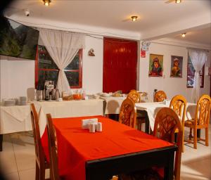 a dining room with tables and chairs with red table cloth at Hotel Valle Mistico in Ollantaytambo
