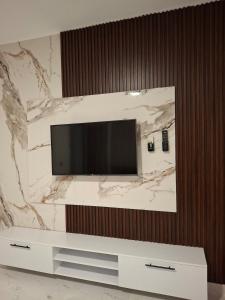 a flat screen tv on a marble wall at 1 room apartment Delta in Sharm El Sheikh