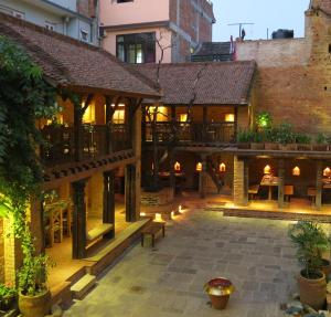 um pátio de um edifício antigo com um restaurante em The Inn Patan em Pātan
