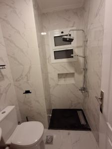 a white bathroom with a toilet and a shower at 1 room apartment Delta in Sharm El Sheikh