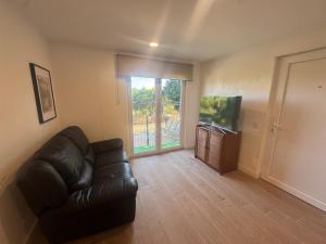 a living room with a leather couch and a television at Casa Oliveira in Silves
