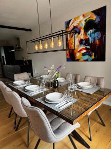 a dining room table with chairs and a painting at Traumhafte Wohnung mit Garten in Wiesbaden