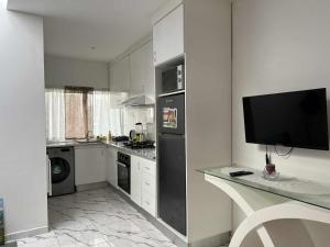 a kitchen with a black refrigerator and a tv at Repousando no terraço in Ribeira Grande