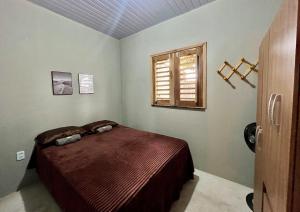 a bedroom with a bed and a window at Chalé 2 - Próximo à igreja do céu in Viçosa do Ceará