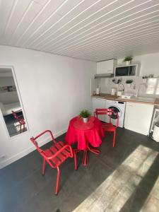 a room with a table and chairs and a kitchen at Coca-Cola Studio near Paris in Saint-Denis
