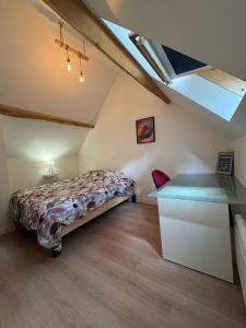Schlafzimmer im Dachgeschoss mit einem Bett und einem Schreibtisch in der Unterkunft Maison de charme en bord de Loire in Montlouis-sur-Loire