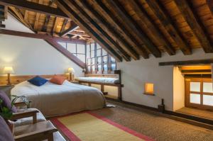 um quarto com uma cama num quarto com tectos em madeira em The Inn Patan em Pātan