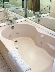 a bath tub with a towel on the side of it at The Maddox Inn in Chincoteague +39 photos