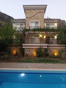 a house with a swimming pool in front of it at Villa Uzumlu in Fethiye