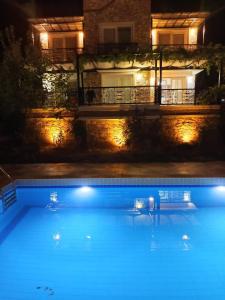 a swimming pool at night with a house in the background at Villa Uzumlu in Fethiye