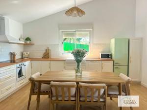 a kitchen with a wooden table with a vase of flowers at Fuente Ghadira Aracena in Aracena