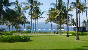a park with palm trees and the ocean in the background at Nadyah Syariah Homestay in Ketapang