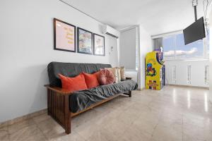 sala de estar con sofá y almohadas de color naranja en Otium Pool Beach Access, en San Juan
