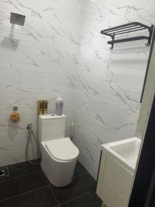 a white bathroom with a toilet and a sink at TGB Buhayra CHALLET & CAMPSITE 