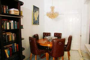 a dining room table with chairs and a chandelier at Adiwinoto villa and Homestay in Banyuwangi