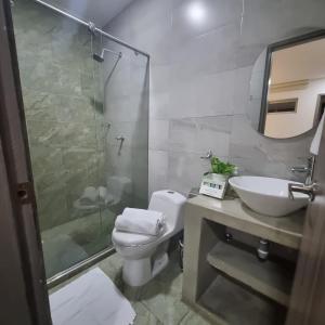 a bathroom with a toilet and a sink and a shower at Hotel Patiño Boutique in Montería