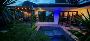a house with a swimming pool at night at GRG Villa Huan in Santo Domingo