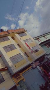 a tall yellow building with windows on the side of it at Hostal Caxamarcorco in Cajamarca