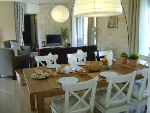 a dining room table with white chairs around it at Villa in Languedoc with Pool near Historic Cities in Rousson