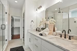 een witte badkamer met een wastafel en een spiegel bij Downtown Oasis Sleeps 12 and 1 and a half miles to Broadway in Nashville +52 foto's