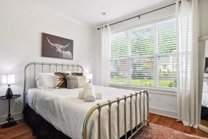 een slaapkamer met een bed en een groot raam bij Downtown Oasis Sleeps 12 and 1 and a half miles to Broadway in Nashville