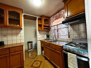 Una cocina con gabinetes de madera y un horno de estufa. en Beachfront Condo Enjoy Paradise!, en Playas de Rosarito