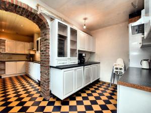 - une cuisine avec des placards blancs et un sol en damier dans l'établissement Stylish Stay with Sauna, à Mesnil-Saint-Blaise