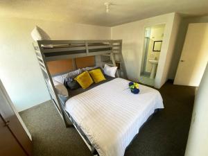 1 dormitorio con litera y almohadas amarillas en Beachfront Condo Enjoy Paradise!, en Playas de Rosarito