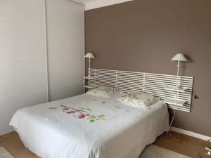 Un dormitorio con una cama blanca con flores. en Attractive Holiday Home in C reste with Pool, en Céreste
