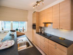 eine Küche mit Holzschränken und einer schwarzen Arbeitsplatte in der Unterkunft Apartment with 2 bedrooms and 2 bathrooms in Middelkerke