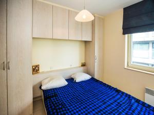 ein Schlafzimmer mit einem blauen Bett mit zwei weißen Kissen in der Unterkunft Apartment with 2 bedrooms and 2 bathrooms in Middelkerke