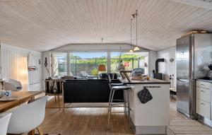 VestervigにあるPet Friendly Home In Vestervig With Wifiのテーブルと椅子のあるキッチンとリビングルーム