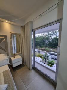 a bedroom with a large glass door leading to a balcony at Hotel Patiño Boutique in Montería