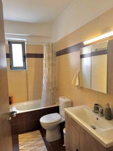 a bathroom with a toilet and a tub and a sink at Anesis home in Gythio