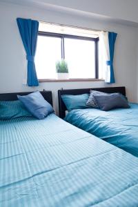 two beds in a room with blue sheets and a window at G63 駅徒歩3分 3人可能 名古屋駅から1駅 3-minute walk from the station in Nagoya