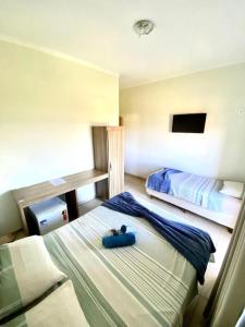 a bedroom with two beds in a room at Hotel Rezende in Villa Nova de Resende