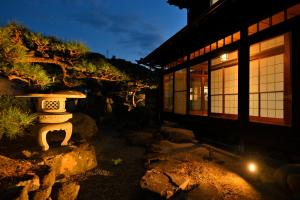 a vase sitting on a rock next to a building at 島宿栞 in Tonosho