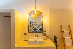a bathroom with a sink and a mirror at Santorini Suites Canggu in Canggu +21 photos