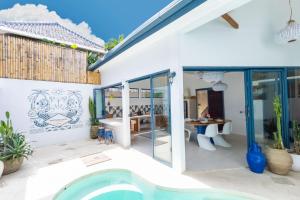 a villa with a swimming pool and a house at Santorini Suites Canggu in Canggu