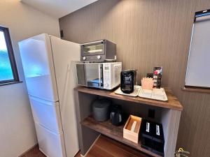 a kitchen with a microwave and a refrigerator at Aoi Garden Takayama 5 minutes walk from Takayama Station Japanese modern style garden view in Takayama
