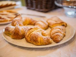 un piatto di croissant e altri prodotti da forno su un tavolo di Hotel Delle Rose a Rapallo