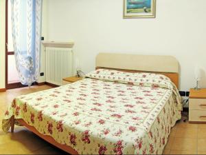 a bedroom with a bed with a floral bedspread at Holiday Home Bardolino with Pool near Lake in Bardolino +23 photos