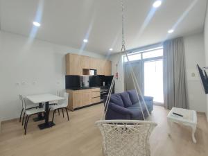 a swing in a living room with a kitchen at Barcelos Habadia Adega in Lijó