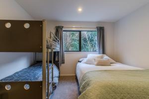 Un dormitorio pequeño con dos camas y una ventana. en Harbour Retreat at St Leonard's, en Dunedin