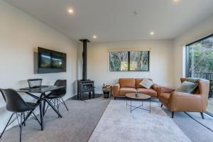 una sala de estar con un sofá y una mesa en Harbour Retreat at St Leonard's, en Dunedin