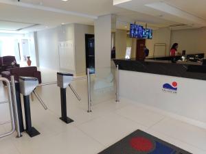 a lobby with a bar with a tv on the wall at Vista Azul Rooftop in São Vicente