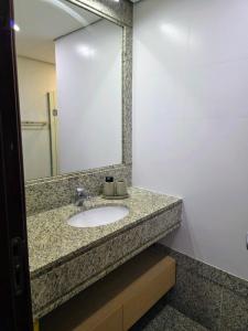 un baño con lavabo y espejo en Quarto 5 estrelas no Comfort Suites!, en Brasilia