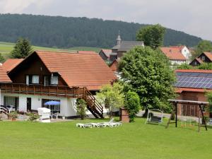 a house with a yard with chairs in the grass at Apartment in Armsfeld mit Pool 