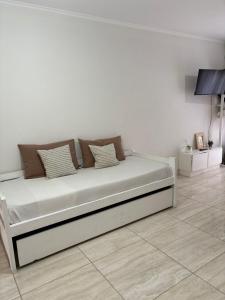a bed in a room with a white wall at Vento Apart in Chivilcoy